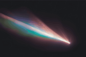 A comet soars through a night sky leaving a trail of colorful lights behind