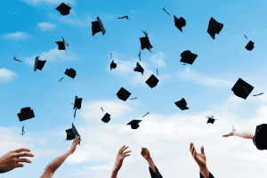 Graduation caps thrown into a clear blue sky